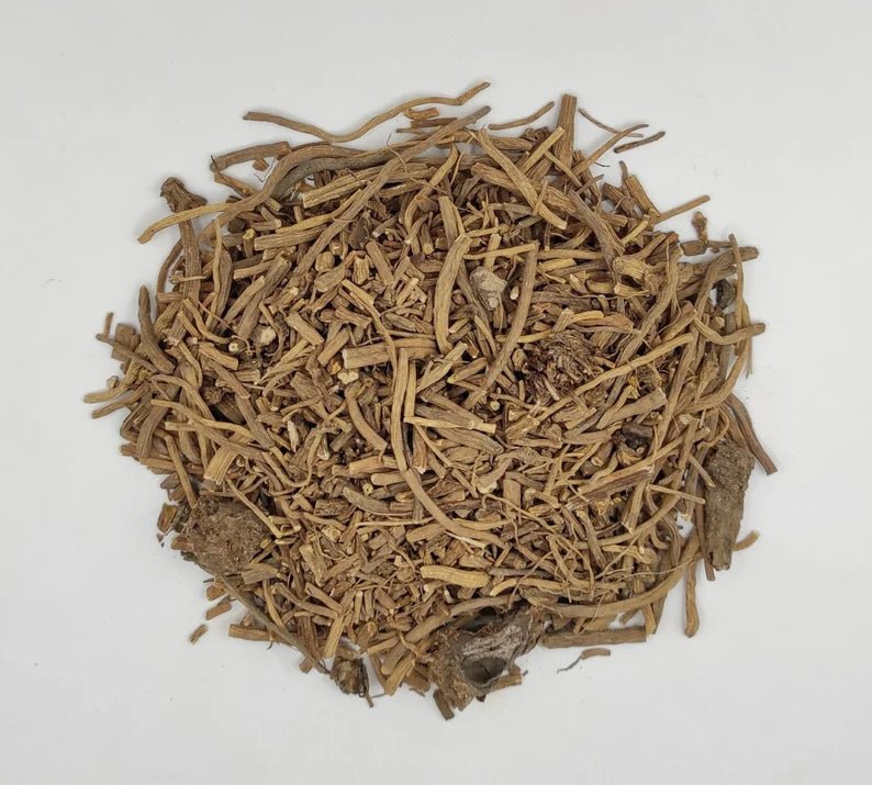 Pile of organic dried valerian root, cut and sifted, on a light gray background