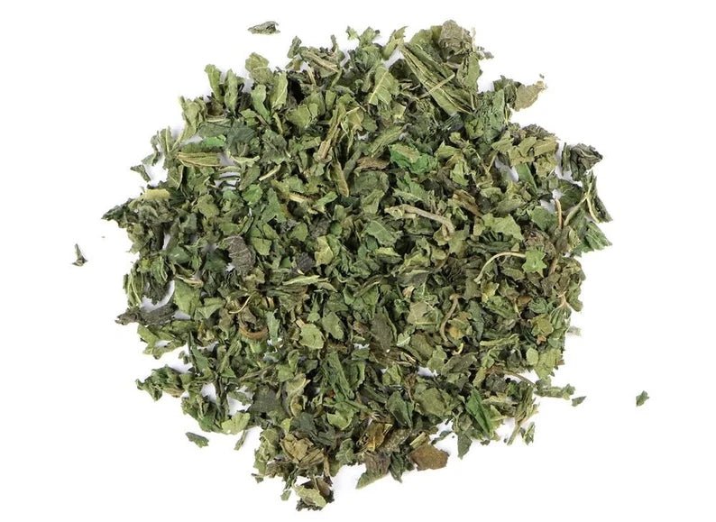Pile of organic dried stinging nettle leaf, cut and sifted, on a white background