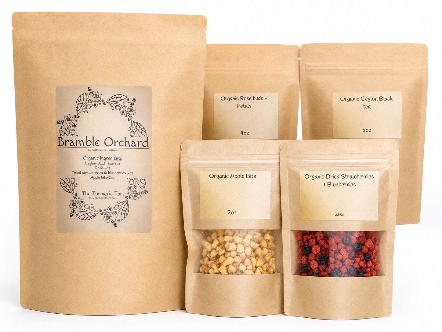 A set of brown bags that are resealable at the top with cream labels, from left to right we see the largest bag with the name of the bundle of tea Bramble orchard, from there we see smaller bags to the right organic apple bits are in the front along with a mix of blueberries.
the rose buds and petals and ceylon black tea are in the back from left to right respectively 