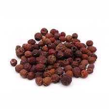 Pile of organic whole dried hawthorn berries (Crataegus) on a white background